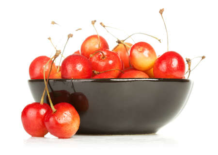 bowl full of cherries isolated on white backgroundの写真素材