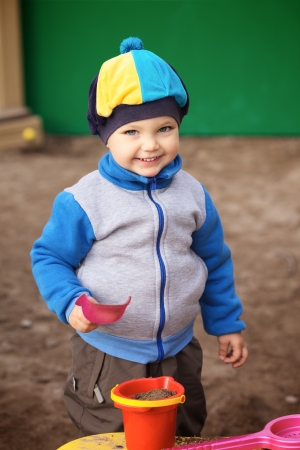 little boy playing in the sandbox at autumnの写真素材