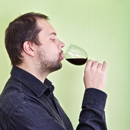 young man drink wine and relax at kitchenの写真素材