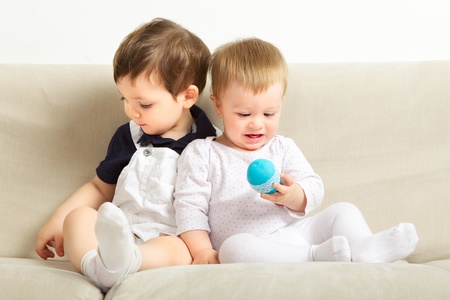 two little boys sitting on couch and playingの写真素材