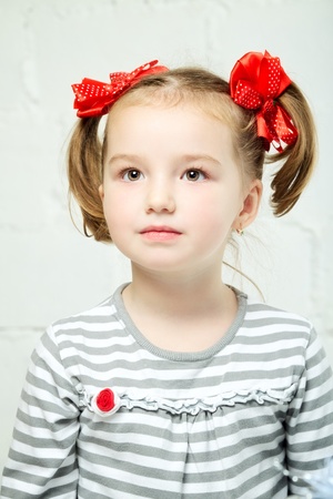beautiful little girl with red bow-knot, portraitの写真素材