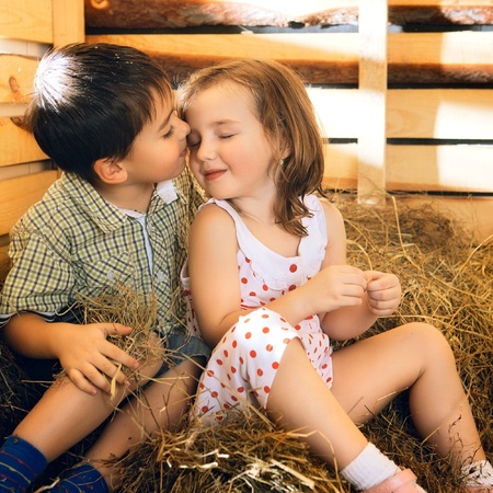 beautiful children on hayloft at sunny dayの写真素材