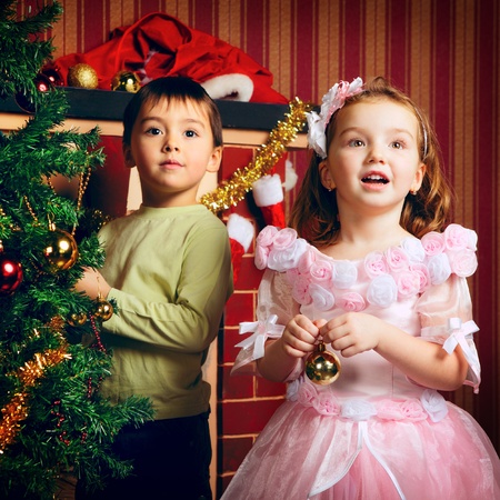two beautiful happy child decorate christmas treeの写真素材