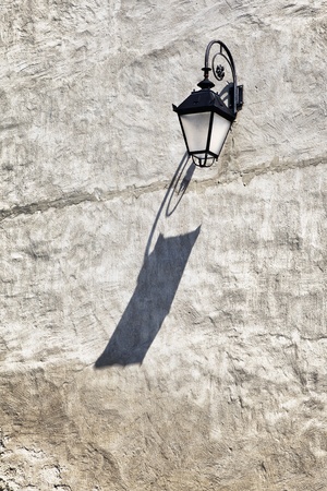 antique street lamp on a wall at dayの写真素材