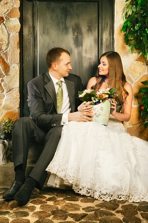 charming bride and groom on porch of houseの写真素材