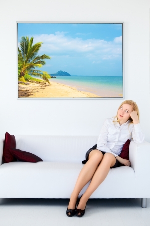 cute businesswoman legs sitting on sofa and dream about vacationの写真素材