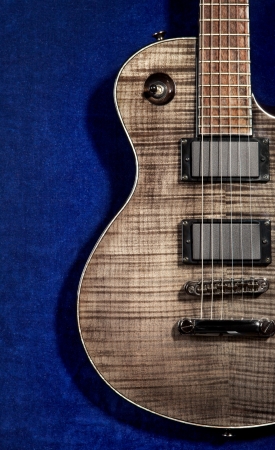 black electric guitar on blue velvet texture
