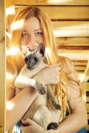 beautiful girl with cat on hayloft at summer dayの写真素材