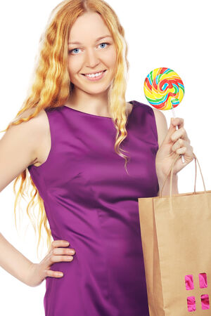 happy girl with shopping bags and lollipop, isolated on whiteの写真素材