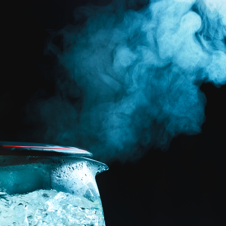 tea kettle with boiling water, dark backgroundの写真素材