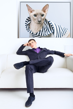 handsome businessman thinks, sitting on couch in his officeの写真素材