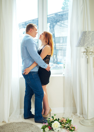 loving mature couple in front of window embraceの写真素材