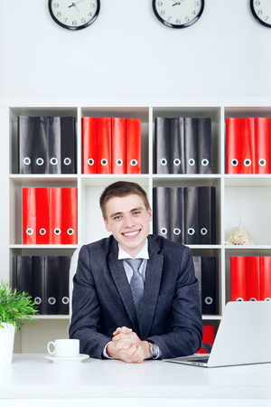 confident young businessman sitting at table in his officeの写真素材