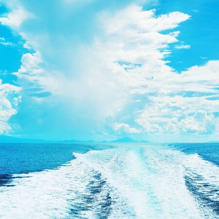 sea with trail of speedboat at sunny dayの写真素材