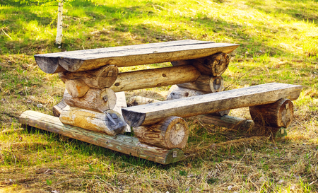 wooden picnic table and bench in forestの写真素材