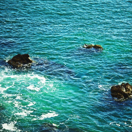 surf in rocky shore, at sunny dayの写真素材