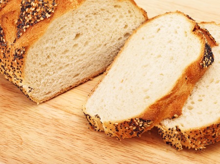 sliced white bread with poppy on cutting boardの写真素材