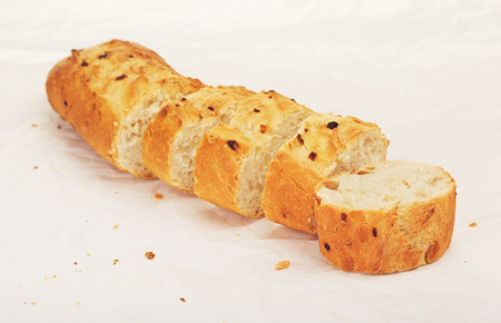 sliced french onion baguette lying on paperの写真素材