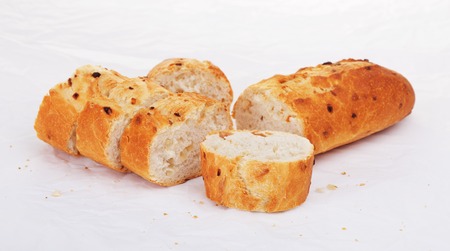 sliced french onion baguette lying on paperの写真素材