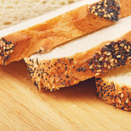 sliced white bread with poppy on cutting boardの写真素材