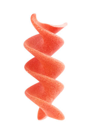 raw red spiral pasta fusilli, isolated on whiteの写真素材