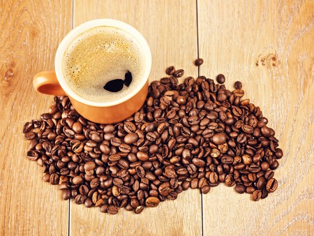 cup of espresso and coffee beans on wooden tableの写真素材