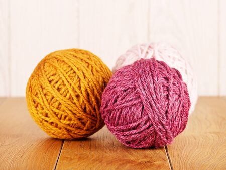 colorful yarn balls lying on wooden backgroundの写真素材