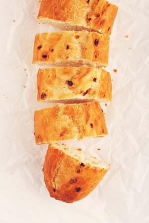 sliced french onion baguette lying on paperの写真素材