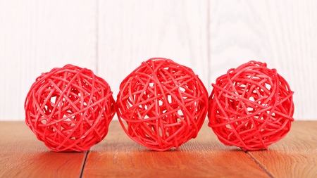 red rattan balls lying on wooden backgroundの写真素材