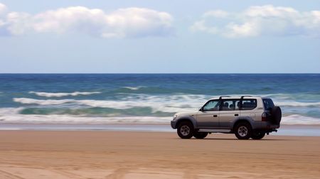 Four-wheel-drive SUV moving on a beach (Fraser Island, Australia)の写真素材