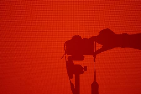 Shadow of a picture taking camera (EOS 300D) in the light of a beamer projecting solid red. (Let me know if you want more like this one :-))の写真素材