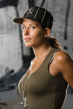 Hip-hop styled girl posing in front of a graffitiの写真素材