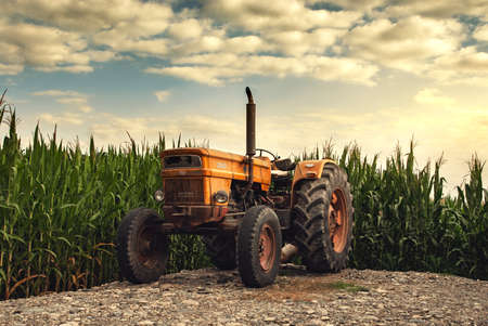 Old tractor near farm fields
