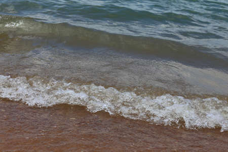 Close up view of waves crashing on the beach on a lake