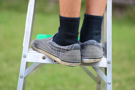A close up view of someone climbing up a ladder