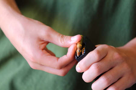 A close up view of someone loading  223 caliber bullets into a ammo clip for a gunの写真素材