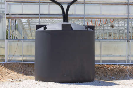 A couple of rain water collection tanks used to catch rain water off of a greenhouse.