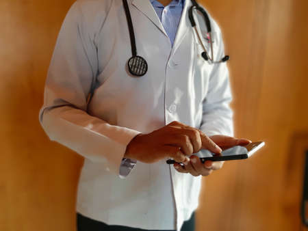 Jaipur,India-Circa 2020: Picture of a doctor looking at a report in his phone. Online Appointments with doctor are going on during this corona virus pandemic to prevent hospital visit for protectionのeditorial素材