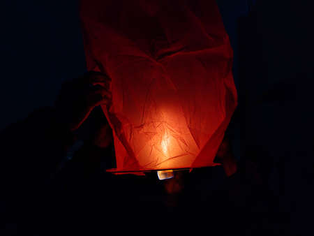Picture of a sky lantern shot at night against black backgroundの写真素材