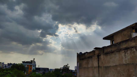 Picture of white and grey clouds in blue sky with sun rays coming from background shot in evening