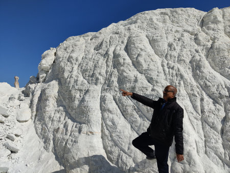 Picture of a man standing on a hill covered with snow shot during daylight. White snowy mountain hills, nature, landscape in winter. Trekking and hiking. Adventure loveの写真素材