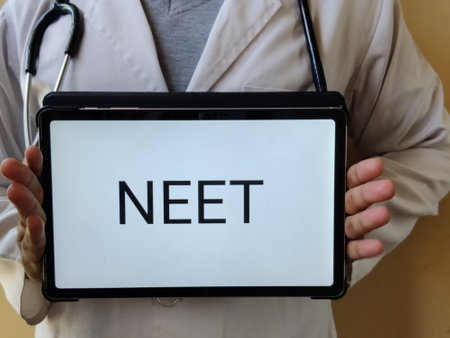 Picture of a doctor wearing a white apron with a stethoscope is holding a placard with NEET written on it. NEET is a medical entrance exam in INDIAの写真素材