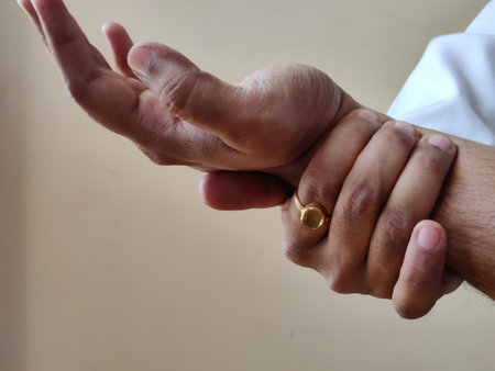 Picture of a doctor wearing a white apron examining pulse of a patientの写真素材