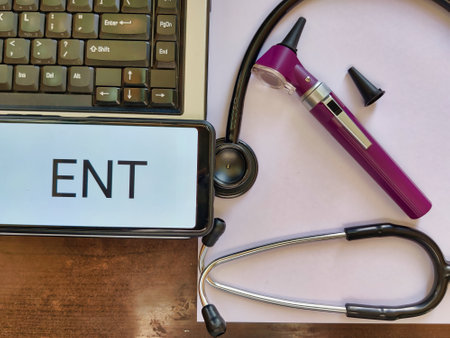 Picture of an otoscope, stethoscope, white paper, laptop and ENT written on a screen. Picture is depicting instruments used by ENT surgeon. Ear Nose Throat surgeon clinicの写真素材