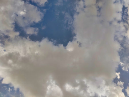 Picture of white clouds shot against blue sky on a cloudy day in summers. Rain in summers.の写真素材