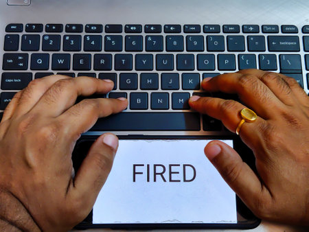 Picture of a person working on a laptop with FIRED written on a screen.の写真素材