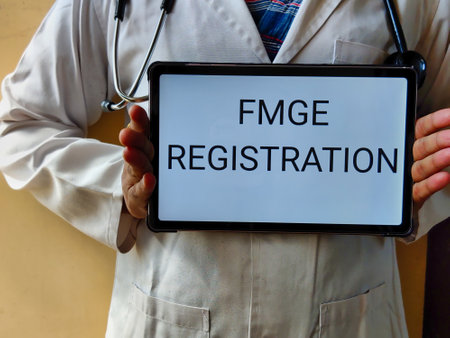 Picture of a doctor wearing a white apron with a stethoscope is holding a placard with FMGE REGISTRATION written on it. FMGE is a medical exam in INDIA for foreign medical graduateの写真素材