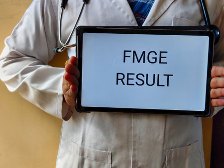 Picture of a doctor wearing a white apron with a stethoscope is holding a placard with FMGE RESULT written on it. FMGE is a medical exam in INDIA for foreign medical graduatesの写真素材