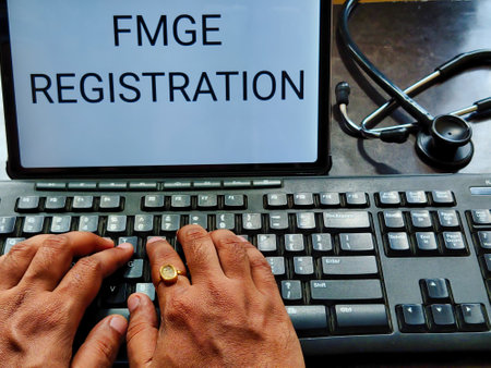 Picture of a doctor working on laptop with FMGE REGISTRATION written on screen and a stethoscope in background. FMGE is a medical exam in INDIA for foreign medical graduatesの写真素材