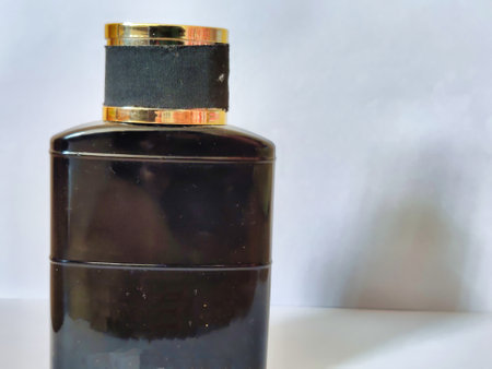 Black perfume bottle on a white background. Selective focus with shallow depth of field.の写真素材